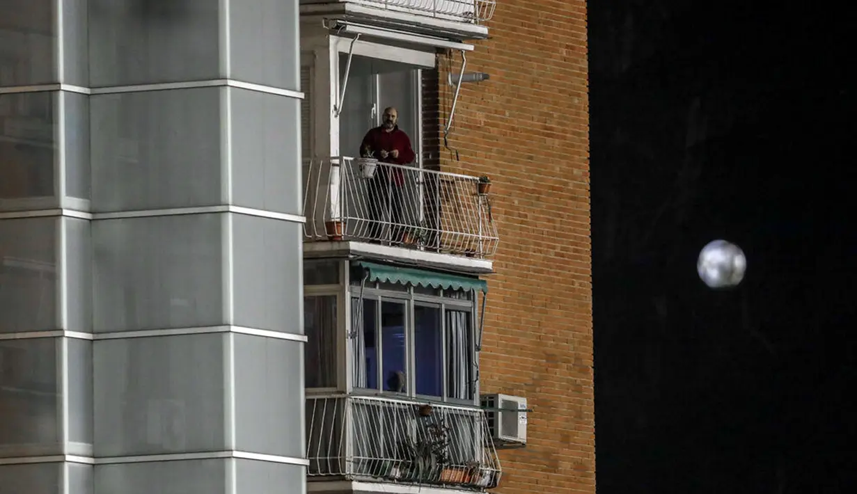 Seorang pria menonton laga Rayo Vallecano melawan Barcelona dari balkon pada pertandingan 16 besar Copa del Rey di Stadion Vallecas, Madrid, Spanyol, Rabu (27/1/2021). Barcelona melaju ke perempat final Copa del Rey usai mengalahkan Rayo Vallecano 2-1. (AP Photo/Manu Fernandez)