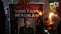 Massa aksi yang tergabung dalam Tim Advokat Penegak Hukum dan Keadilan (Tampak) menunjukkan poster bergambar Brigadir Yosua Hutabarat atau Brigadir J saat aksi 1000 lilin atas kematiannya di Bundaran HI, Jakarta, Jumat (22/7/2022). Aksi tersebut sebagai bentuk keadilan terkait kematian Brigadir J yang diduga akibat penyiksaan. (Liputan6.com/Faizal Fanani)