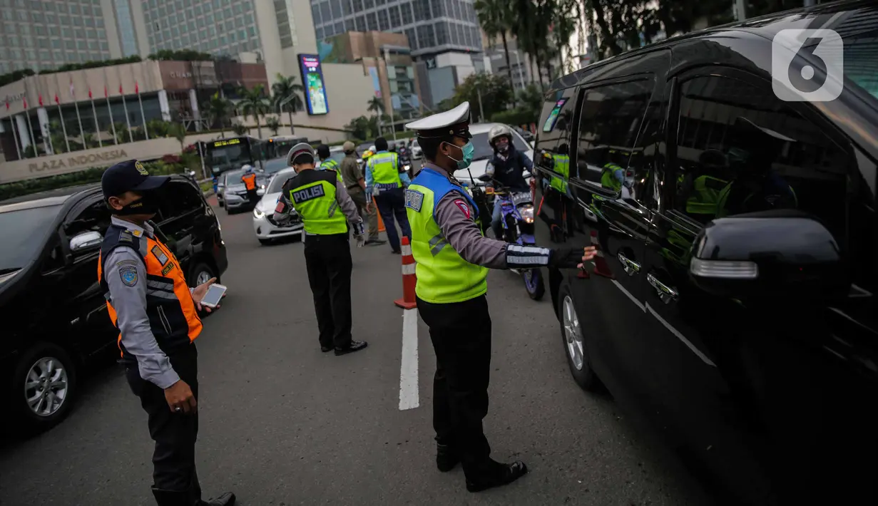 Petugas gabungan dari Polisi, Dishub, dan Satpol PP mengimbau pengguna kendaraan saat melakukan Pengawasan Pelaksanaan PSBB di Bundaran HI, Jakarta, Senin (13/4/2020). Dalam pengawasan tersebut petugas mengimbau masyarakat untuk menggunakan masker saat berpergian. (Liputan6.com/Faizal Fanani)