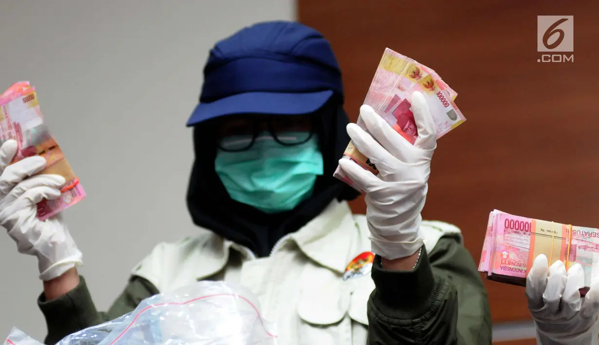 Petugas KPK menunjukkan barang bukti hasil OTT Bupati Nganjuk Taufiqurrahman saat rilis di Gedung KPK, Jakarta, Kamis (26/10). KPK menyita uang Rp 298.020.000,- dan menetapkan lima orang tersangka. (Liputan6.com/Helmi Fithriansyah)