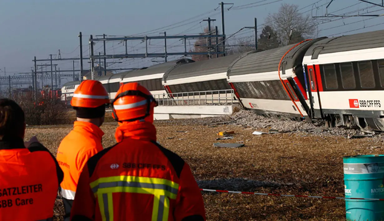 Petugas saat melihat kondisi kereta yang bertabrakan di Zurich, Swiss, (20/2/2015). Kereta bertabrakan di Swiss yang menyebabkan beberapa orang terluka dan rute komuter tergangu. (Reuters/ Arnd Wiegmann)