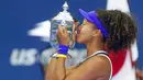 Petenis Jepang, Naomi Osaka, mencium trofi usai menjuarai AS Terbuka di Arthur Ashe Stadium, New York, Minggu (13/9/2020). Naomi Osaka mengalahkan Victoria Azarenka 1-6, 6-3, dan 6-3. (AP Photo/Seth Wenig)