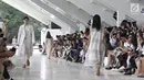 Penonton menyaksikan model memeragakan busana rancangan desainer Sapto Djojokartiko di Jakarta, Kamis (20/9). Sapto memamerkan 70 busana Spring/Summer 2019 untuk merayakan 10 tahun karyanya di dunia fesyen. (Liputan6.com/Herman Zakharia)