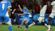 Bek Israel #12 Noam Ben Harosh menendang bola melewati bek Mali #04 Mamadou Tounkara pertandingan Grup D Olimpiade 2024 di Stadion Parc des Princes, Prancis, Kamis (25/7/2024) dini hari WIB. (FRANCK FIFE / AFP)