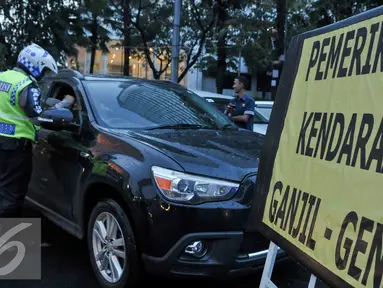 Petugas Kepolisian melakukan penilangan kepada pelanggar ganjil genap di Bundaran HI, Jakarta, Selasa (30/8). Sejumlah kendaraan masih didapati melanggar aturan ganjil genap yang telah resmi diberlakukan. (Liputan6.com/Yoppy Renato)