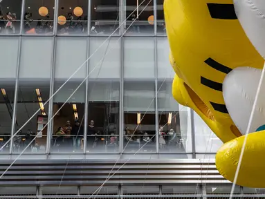 Orang-orang mennonton dari gedung kantor ketika balon Spongebob Squarepants memeriahkan parade perayaan Hari Thanksgiving di kawasan Sixth Avenue, New York, Kamis (28/11/2019). Parade yang membelah jalanan kota New York ini selalu ditunggu setiap tahunnya. (AP Photo/Jeenah Moon)