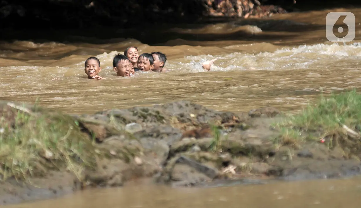 Anak-anak berenang di Kali Ciliwung, Depok, Jawa Barat, Minggu (27/6/2021). Keterbatasan lahan bermain di tengah masa pandemi COVID-19 membuat anak-anak memilih untuk berenang di Kali Ciliwung sebagai wahana alternatif saat libur sekolah. (merdeka.com/Iqbal S. Nugroho)