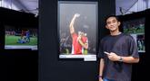 Pemain Timnas Indonesia, Rizky Ridho berfoto bersama dengan karya foto milik Ady Sesotya yang memperlihatkan dirinya tengah berselebrasi mencium logo garuda di jerseynya setelah Skuad Garuda menang 1-0 atas Bahrain di Kualifikasi Piala Dunia 2026 saat pameran foto Media Cup 2025 bertema "Timnas Indonesia dari Masa ke Masa" di Cibis, Cilandak, Jakarta Selatan, Selasa (28/10/2025). (Bola.com/Bagaskara Lazuardi)