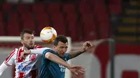 Penyerang AC Milan, Mario Mandzukic berebut bola dengan pemain Red Star Belgrade, Nemanja Milunovic pada leg pertama babak 32 besar Liga Europa di Rajko Mitic Stadium, Serbia (19/2/2021). Hasil imbang 2-2 menjadi keuntungan Milan yang akan menjadi tuan rumah di leg kedua. (AP Photo/Darko Vojinovic)