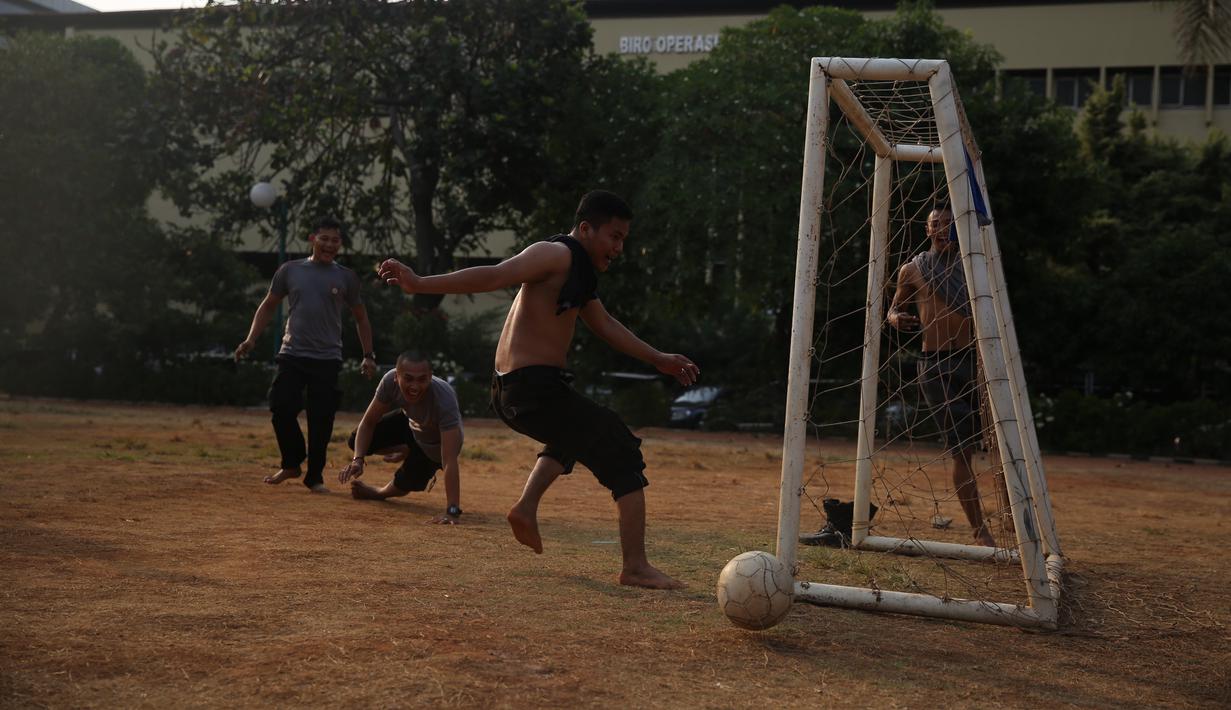 Polisi dari kesatuan Sabhara merenggangkan otot dengan bermain bola di Kawasan Polda Metro, Jakarta, Selasa (13/10/2015). Pihak Kepolisian dan TNI bersiap siaga menjelang laga Final Piala Presiden 2015. (Bola.com/Nicklas Hanoatubun).