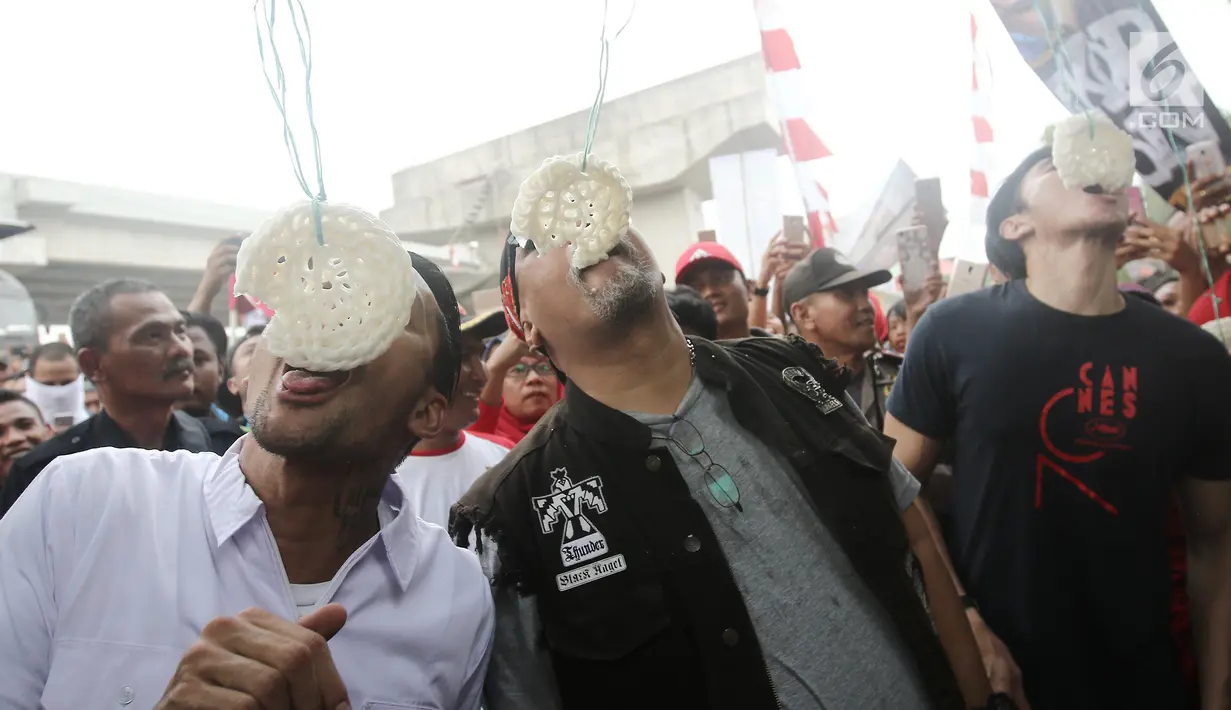 Aktor Tora Sudiro, Vino G Bastian dan Indro Warkop mengikuti lomba makan kerupuk pada Festival Kalimalang di Jakarta, Kamis (17/8). Mereka menghadiri festival Kalimalang dalam rangka promo film Warkop DKI: Reborn Part 2. (Liputan6.com/Herman Zakharia)