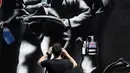 Seorang pria memotret mural bertema virus corona COVID-19 di Los Angeles, Amerika Serikat, Selasa (14/4/2020). (AP Photo/Marcio Jose Sanchez)