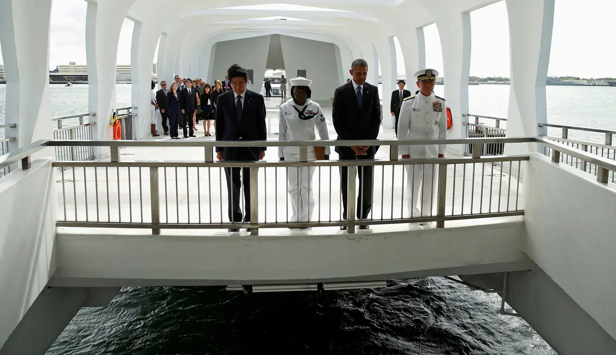 Presiden AS, Barack Obama dan PM Jepang, Shinzo Abe menundukan kepala usai berpartisipasi dalam upacara peletakan karangan bunga di atas kapal Memorial USS Arizona di Pearl Harbor, Hawaii, (27/12). (REUTERS/Kevin Lamarque)
