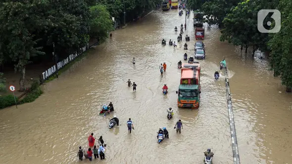 Sejumlah pengendara motor dan warga menerobos genangan air di jalan Sultan Agung , kota Bekasi, Jawa Barat, Selasa (4/3/2025). (Liputan6.com/Herman Zakharia)