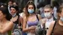 Pembelanja yang mengenakan masker berjalan di sepanjang Oxford Street di pusat kota London, Senin (5/7/2021). PM Inggris Boris Johnson berencana mencabut sebagian besar pembatasan wilayah selama pandemi Covid-19, termasuk penggunaan masker dan jaga jarak mulai 19 Juli. (DANIEL LEAL-OLIVAS/AFP)