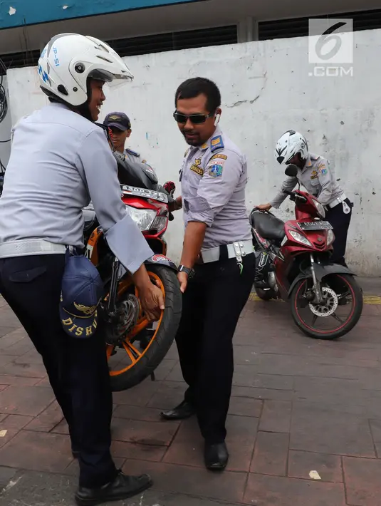 Petugas Dishub DKI mengangkut sepeda motor yang terjaring operasi penertiban di kawasan Pasar Tanah Abang, Jakarta, Senin (21/5). Razia pada hari kelima puasa tersebut digelar untuk menertibkan parkir liar selama Ramadan. (Liputan6.com/Arya Manggala)