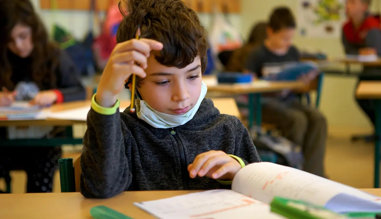 Seorang anak laki-laki terlihat belajar di dalam kelas di sebuah sekolah di Praha, Republik Ceko (25/5/2020). Para siswa sekolah dasar juga diizinkan untuk kembali bersekolah dalam kelompok-kelompok kecil. (Xinhua/Dana Kesnerova)