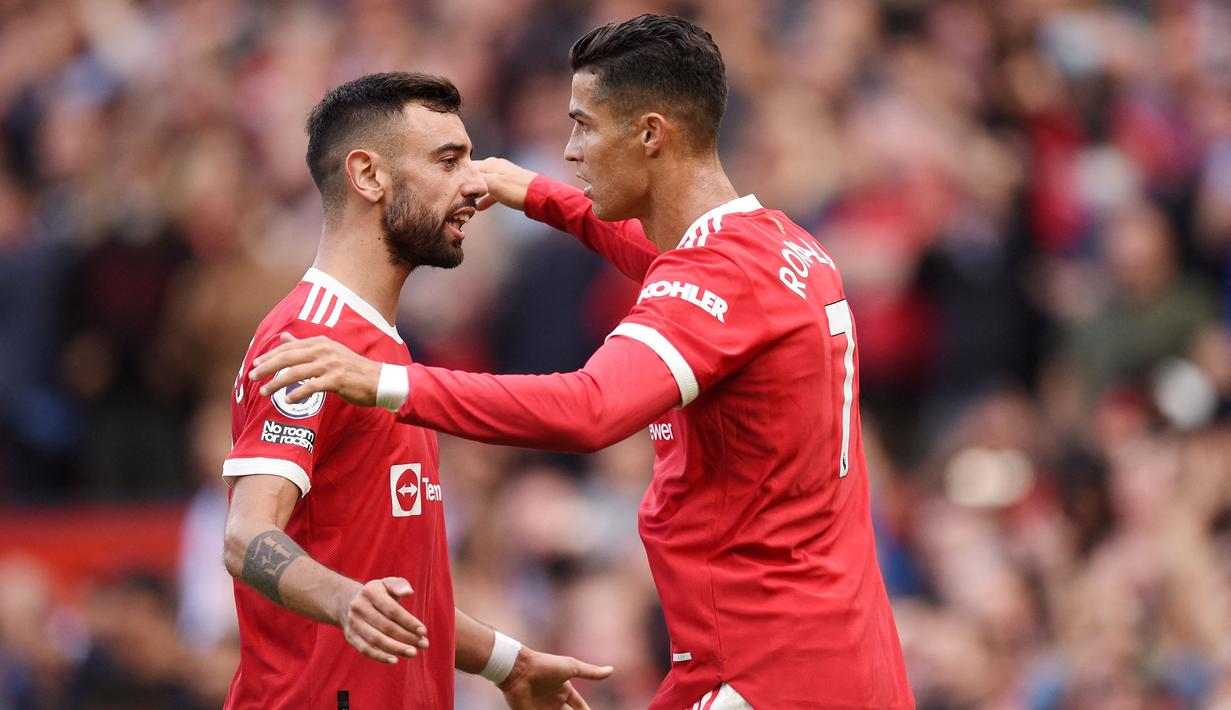 Bruno Fernandes dan Cristiano Ronaldo - Bruno dan CR7 merupakan rekan di Timnas Portugal. Pulangnya CR7 ke Old Trafford membuat mereka membentuk duet sensasional di lini depan Manchester United. (AFP/Oli Scarff)