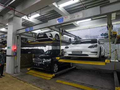 Petugas mengatur penyimpanan mobil rampasan dari koruptor di Rumah Penyimpanan Benda Sitaan dan Rampasan (Rupbasan) Komisi Pemberantasan Korupsi (KPK) di Jalan Dewi Sartika, Cawang, Kramat Jati, Jakarta Timur, Selasa (7/1/2025). (merdeka.com/Arie Basuki)
