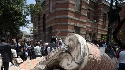 Sebuah mobil yang hancur tertimpa bangunan setelah gempa mengguncang Kota Meksiko (19/9). Gempa terjadi tepat 32 tahun sejak gempa dahsyat menewaskan ribuan orang di Mexico City pada 1985. (AFP Photo/Alfredo Estrella)