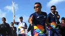 Aktor Hamish Daud (kedua kiri) membawa obor pada kirab obor Asian Games 2018 di Pantai Kuta, Bali, Senin (23/7). Torch Relay Asian Games 2018 melintasi empat kabupaten di Bali dengan arak-arakan berkeliling di sejumlah obyek wisata. (AFP/SONNY TUMBELAKA)