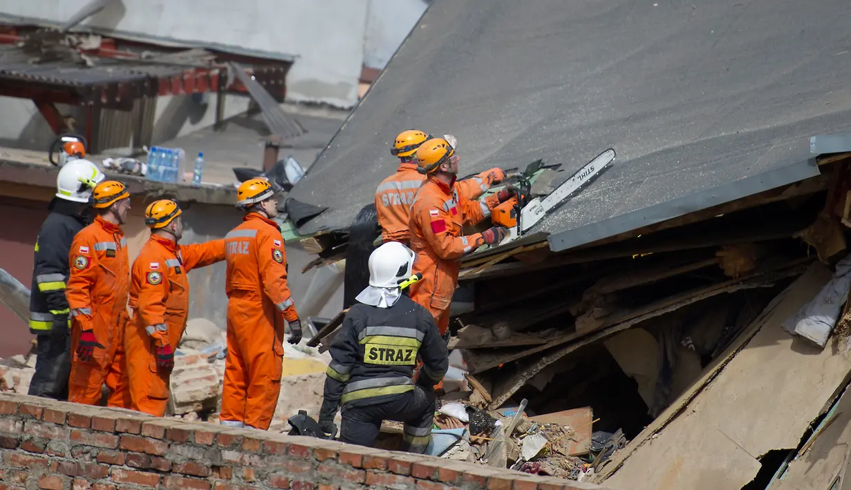 Petugas penyelamat mencari korban di reruntuhan sebuah apartemen tua yang ambruk di Swiebodzce, Polandia, Sabtu (8/4). Apartemen yang rubuh itu merupakan bangunan tua yang telah berdiri sebelum Perang Dunia II berlangsung. (Natalia DOBRYSZYCKA/AFP)