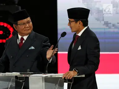 Capres dan Cawapres nomor urut 02 Prabowo Subianto-Sandiaga Uno berbincang saat mengikuti Debat Pilpres 2019 kelima di Jakarta, Sabtu (13/4). Debat kelima merupakan debat terakhir yang mengambil tema Ekonomi, Kesejahteraan Sosial, Keuangan dan Investasi. (Liputan6.com/Johan Tallo)