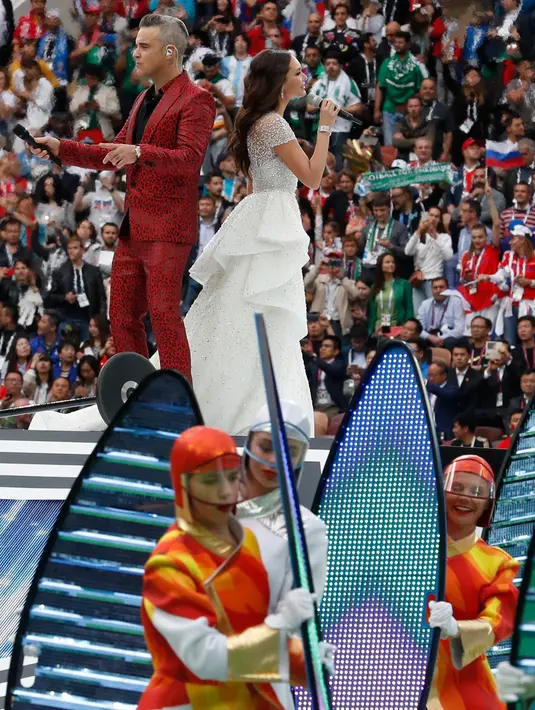Penyanyi asal Inggris, Robbie Williams, berduet dengan penyanyi soprano Rusia Aida Garifullina pada upacara pembukaan Piala Dunia 2018 di Stadion Luzhniki, Moskow, Kamis (14/6). Keduanya berkolaborasi di lagu Angel milik Williams. (AP/Antonio Calanni)