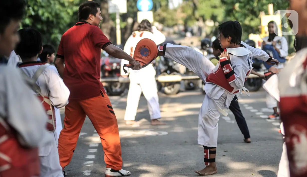 Pelatih atau Saboeum Taekwondo Indonesia Manroe Club saat melatih murid di kawasan Kanal Banjir Timur (KBT), Jakarta Timur, Senin (16/8/2021). Meski di ruang terbuka, latihan berlangsung dengan menerapkan protokol kesehatan. (merdeka.com/Iqbal S. Nugroho)