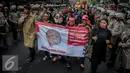 Sebuah spanduk bergambar bocah dibawa saat demo tolak Ahok di Jakarta, Rabu (21/9). Dalam aksinya mereka melakukan longmarch dari Raden Saleh menuju KPUD Jakarta. (Liputan6.com/Faizal Fanani)
