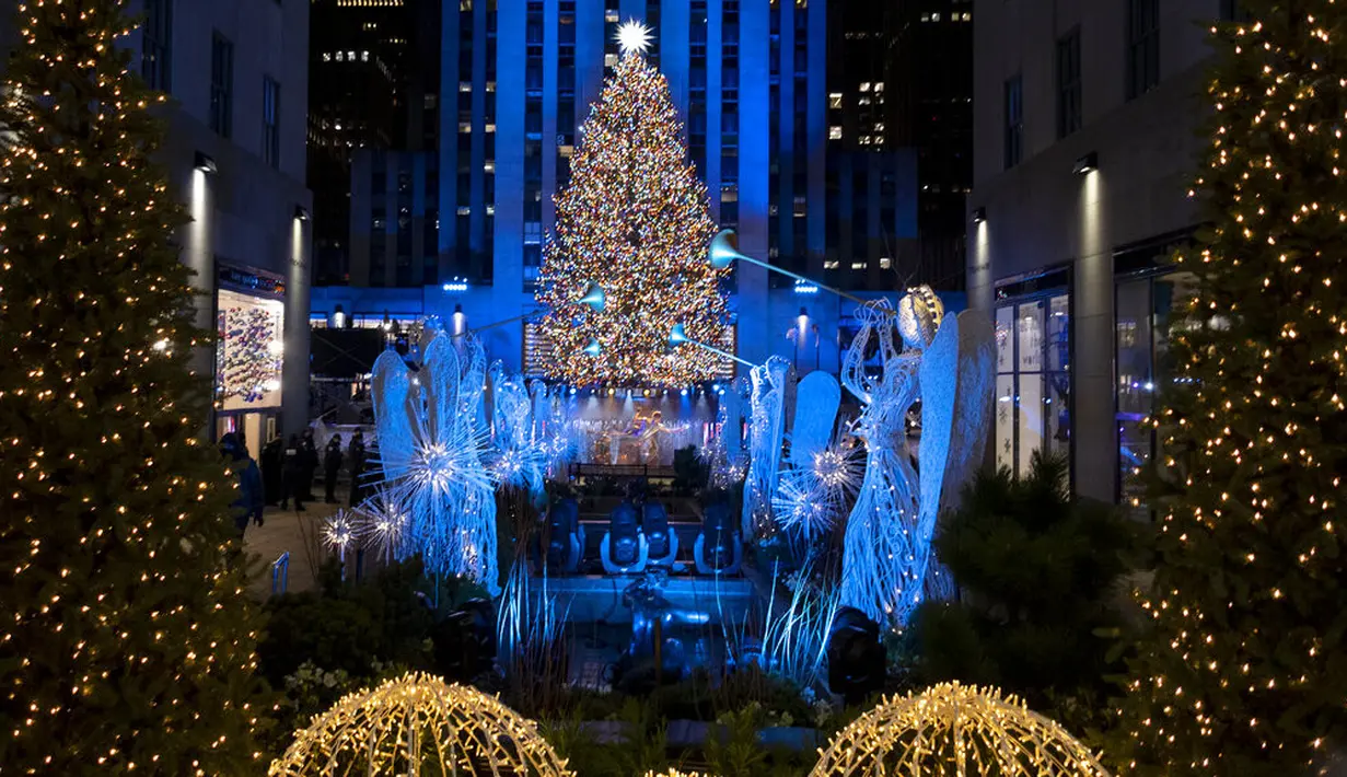 Lebih dari 50.000 lampu menghiasi Pohon Natal Rockefeller Center setinggi 75 kaki pada upacara tahunan pencahayaan di New York, Rabu (2/11/2020). Upacara yang digelar pada masa pandemi COVID-19 ini mewajibkan pengunjung untuk memakai masker, pembatasan waktu, dan jaga jarak. (AP Photo/Craig Ruttle)
