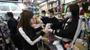 Warga menerima masker wajah gratis dalam sebuah toko di Tsuen Wan, Hong Kong, Selasa (28/1/2020). Hong Kong terkonfirmasi memiliki delapan kasus infeksi virus corona. (AP Photo/Achmad Ibrahim)
