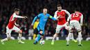 Gelandang Barcelona, Andres Iniesta berusaha membawa bola dari kawalan tiga pemain Arsenal pada leg pertama 16 besar Liga Champions di Stadion Emirates, Inggris (24/2). Barcelona menang atas Arsenal dengan skor 2-0. (Reuters/Dylan Martinez)