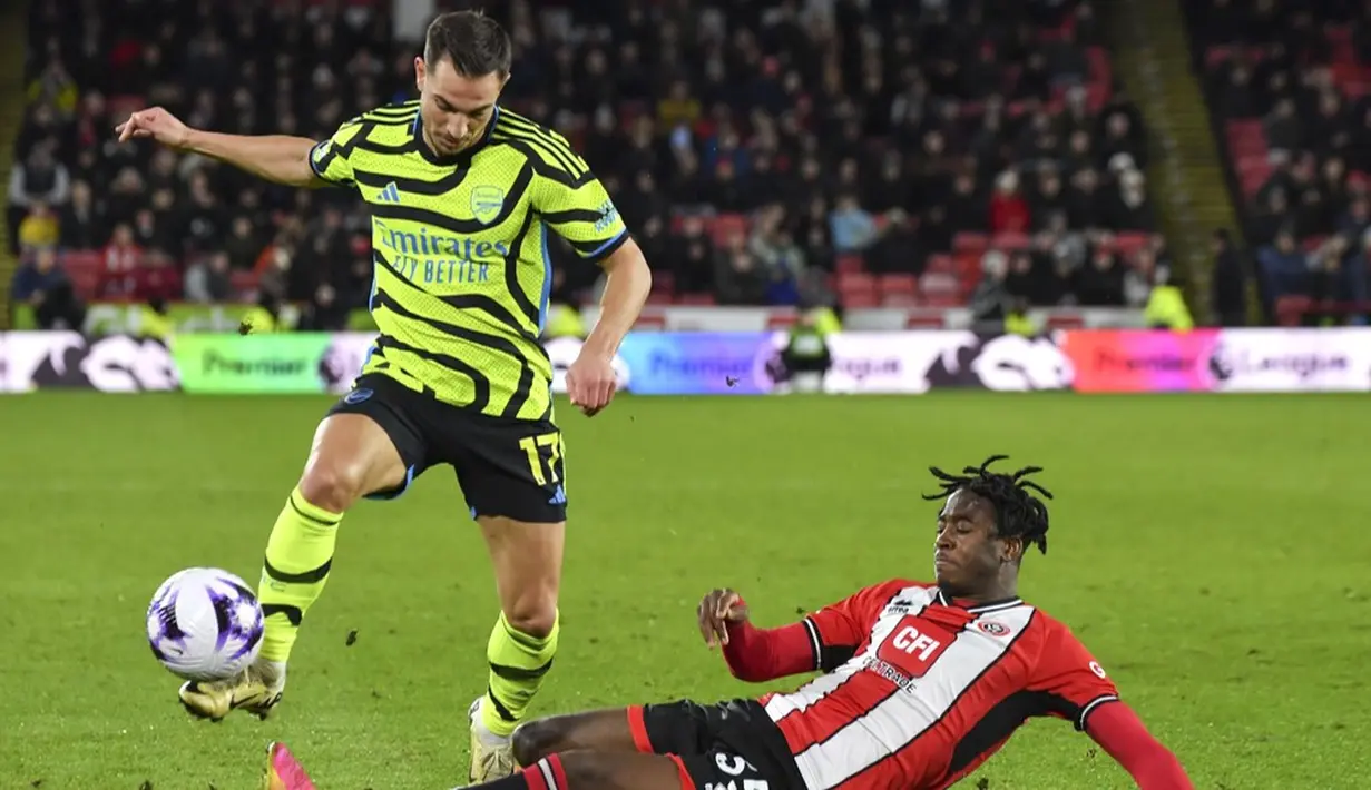 Pemain Sheffield United, Andre Brooks, berusaha mengadang pemain Arsenal, Cedric Soares, dalam laga pekan 27 Premier League 2023/2024 yang dihelat di Bramall Lane, Selasa (5/3/2024). (AP Photo/Rui Vieira)