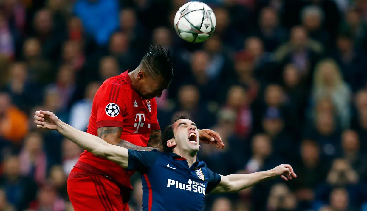 Bek Atletico Madrid, Diego Godin (kanan) berebut bola udara dengan bek Muenchen, Jerome Boateng di Liga Champions di Allianz Arena (4/5). Meski kalah 2-1 dari Munchen, Atletico melaju ke final dengan aggregat gol tandang. (Reuters/Ralph Orlowski)