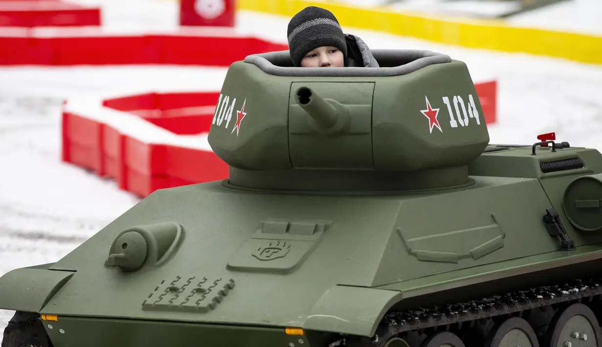 Seorang anak laki-laki mengendarai model tank T-34 era Soviet yang legendaris di objek wisata petualangan anak-anak Tankodrom di taman Sokolniki di Moskow, Rusia (6/1/2020). Model tank ini memiliki mesin pembakaran internal dan kontrol seperti aslinya. (AP Photo/Alexander Zemlianichenko)
