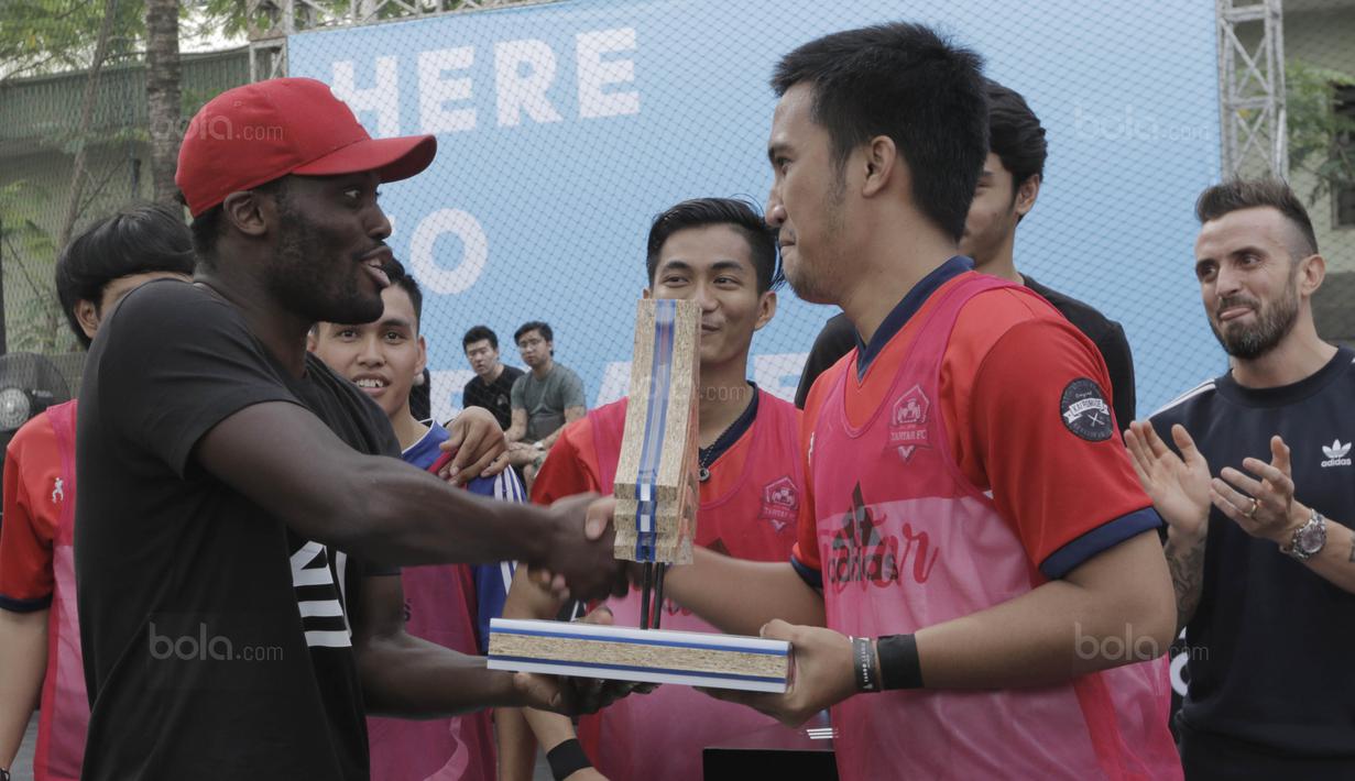 Pemain Persib, Michael Essien memberikan trofi kepada pemenang turnamen Adidas Tango League di Senayan City, Jakarta, Minggu (13/8/2017). Acara ini merupakan bagian dari peluncuran sepatu anyar Adidas. (Bola.com/M Iqbal Ichsan)