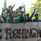 Mahasiswa memegang spanduk bertuliskan “Tolak Rohingya” saat berdemonstrasi menentang kedatangan pengungsi Rohingya di depan Dewan Perwakilan Rakyat (DPR) di Banda Aceh, Rabu (27/12/2023). Aksi diikuti oleh ratusan mahasiswa dari berbagai universitas. (CHAIDEER MAHYUDDIN/AFP)