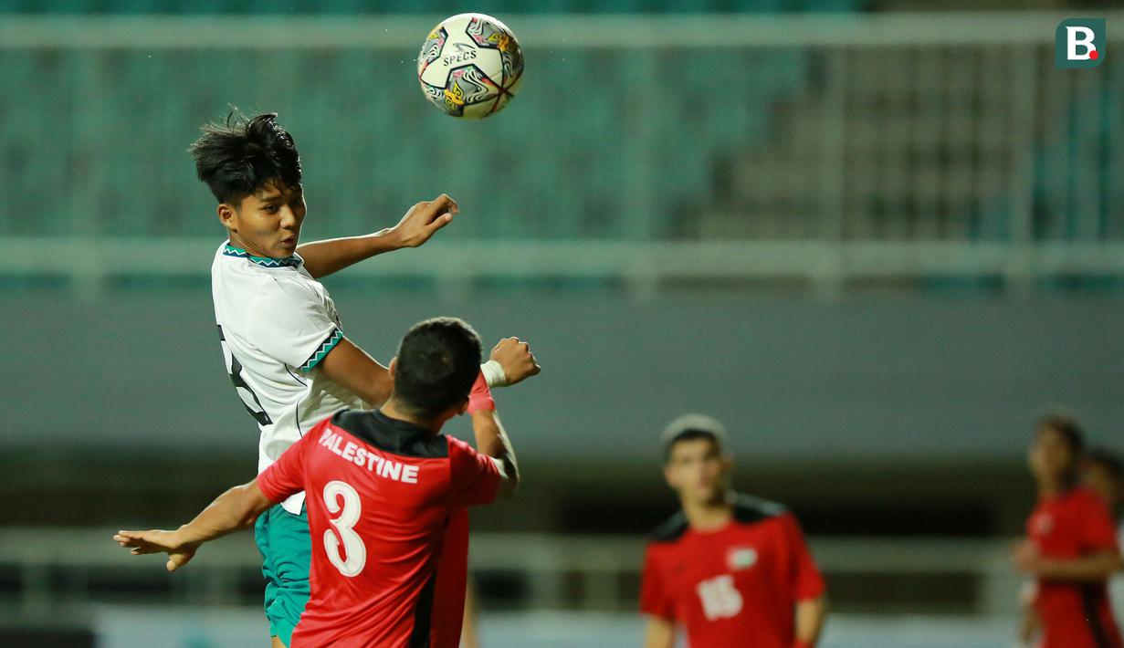 Pemain Timnas Indonesia U-17, Arkhan Kaka (atas) berduel udara dengan pemain Palestina, Mohamad Nouri pada laga Grup B Kualifikasi Piala Asia U-17 2023 antara Timnas Indonesia menghadapi Palestina di Stadion Pakansari, Bogor, Jumat (7/10/2022). (Bola.com/M Iqbal Ichsan)