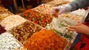 Pedagang melayani pembeli yang berbelanja untuk persiapan Tahun Baru Imlek di pasar Dihua Street di Taipei, Selasa (29/1). Warga Taiwan mulai berburu makanan lezat, kue kering dan barang lainnya di pasar menjelang Imlek. (AP/Chiang Ying-ying)
