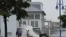 Sekelompok orang mengambil foto ombak tinggi di sebelah Southern Yacht Club di Danau Pontchartrain saat Badai Ida mendekat, di New Orleans (29/8/2021). (AP Photo/Gerald Herbert)