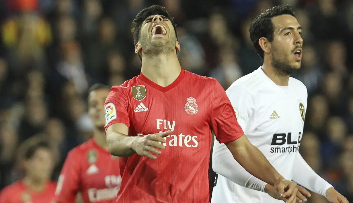 Gelandang Real Madrid, Marco Asensio, tampak kecewa usai gagal mencetak gol ke gawang Valencia pada laga La Liga 2019 di Stadion Mestalla, Rabu (3/4). Valencia menang 2-1 atas Real Madrid. (AP/Alberto Saiz)