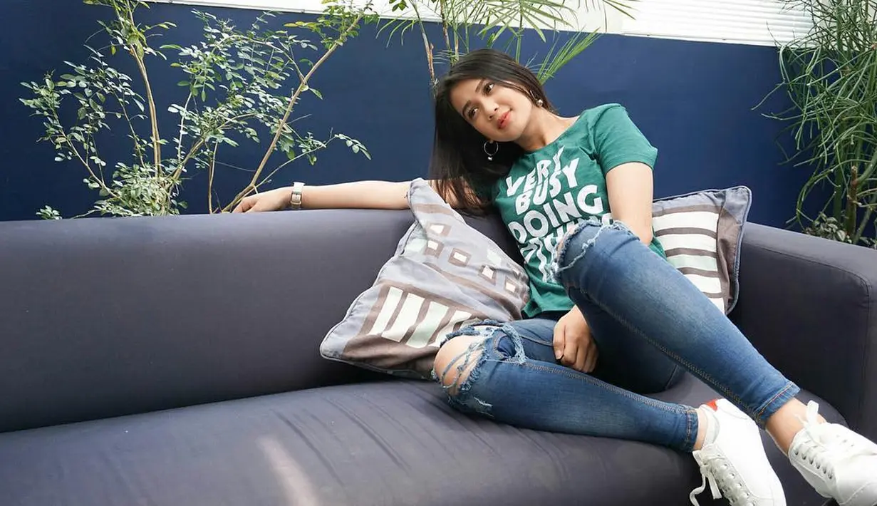 Hal yang sama juga terjadi dengan Dea di foto ini. Ia memakai ripped jeans yang dipadukan dengan kaus hijau dan sneakers putihnya. Sebagai pemanis, Dea memakai hoop rings di telinganya. (Instagram/deaaannisa)