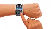 iWatch ketika dipakai. Terlihat seperti iPhone mini dengan tombol home ikonik yang tak ditanggalkan dengan sistem operasi iOS di dalamnya. (credit foto: Jivaldi.com)