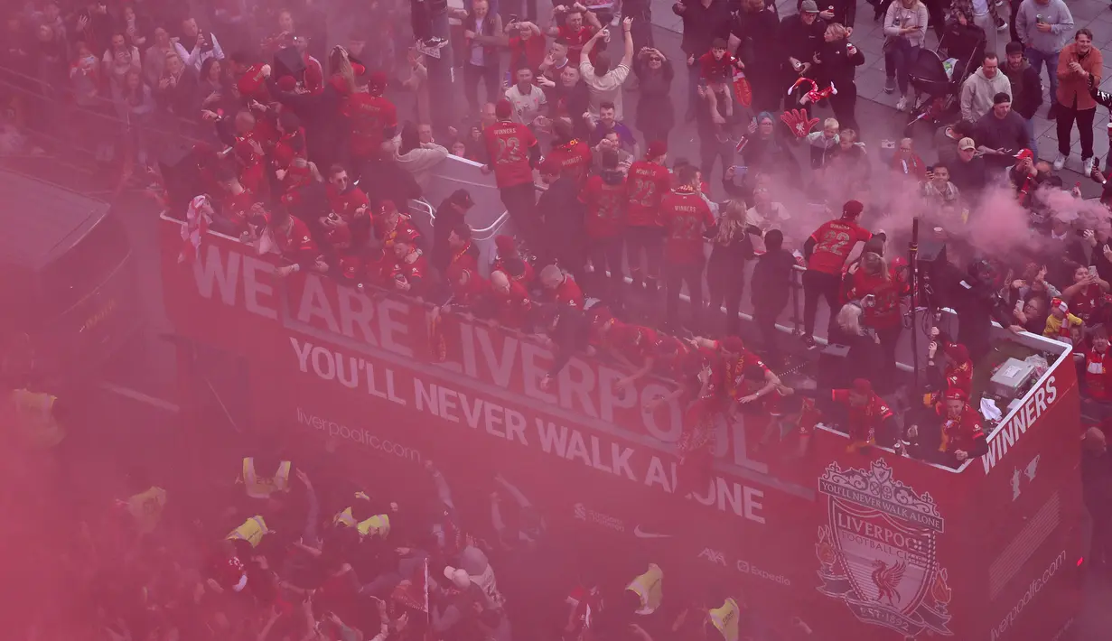 Ribuan fans Liverpool memadati jalan-jalan kota untuk menyambut tim kebanggaan mereka yang melakukan parade di atas bus terbuka pada Minggu (29/05/2022) waktu setempat. Musim ini, The Reds berhasil meraih dua trofi yaitu Piala FA dan Piala Liga Inggris. (AFP/Oli Scarff)