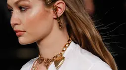 Model Gigi Hadid memperagakan busana koleksi Versace Pre-Fall 2019 di New York (2/12). Gigi Hadid tampil dengan berbagai kalung dan pin saat berjalan di atas catwalk. (AFP Photo/JP Yim)