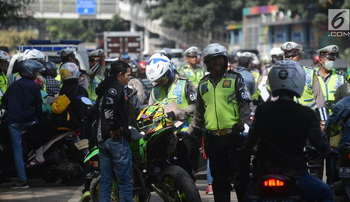 Polisi lalu lintas menggelar razia atau yang disebut Operasi Patuh Jaya 2018 di Jalan DI Panjaitan, Jakarta Timur, Jumat (27/4). Operasi ini bertujuan untuk menertibkan pengendara motor maupun mobil terhadap aturan lalu lintas. (Merdeka.com/Imam Buhori)