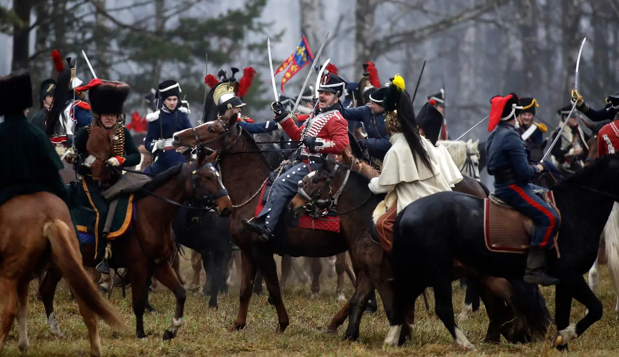 Sejumlah peserta berpakaian seperti tentara Rusia dan Prancis tahun 1812 mengunggang kuda melakukan adegan pertempuran di Belarus (26/11). Acara ini juga untuk memperingati 205 tahun perang Berezina. (AP Photo/Sergei Grits)