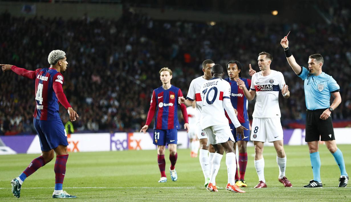 Wasit Istvan Kovacs memberikan kartu merah kepada pemain Barcelona, Ronald Araujo, saat melawan Paris Saint-Germain pada duel leg kedua perempat final Liga Champions 2023/2024 Stadion Olimpic Lluis Companys, Rabu (17/4/2024). (AP Photo/Joan Monfort)