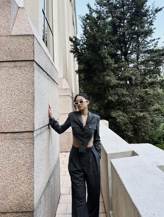 Beri sentuhan edgy lewat padu padan cut out blazer dan wide leg pants. Agar makin kece, tambahkan aksesori berupa kacamata hitam. [Instagram/azizahsalsha_]